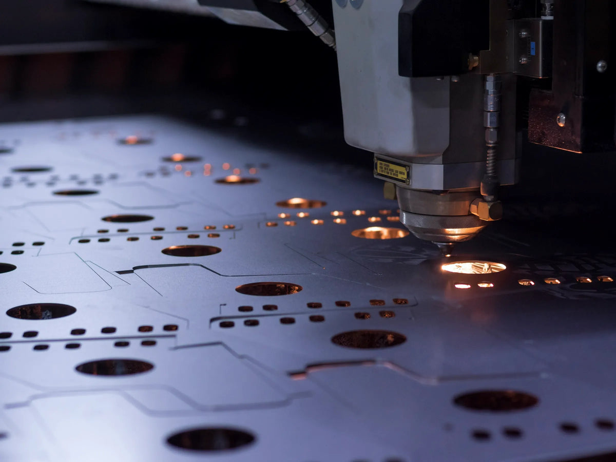 Fiber laser head cutting holes in a steel sheet