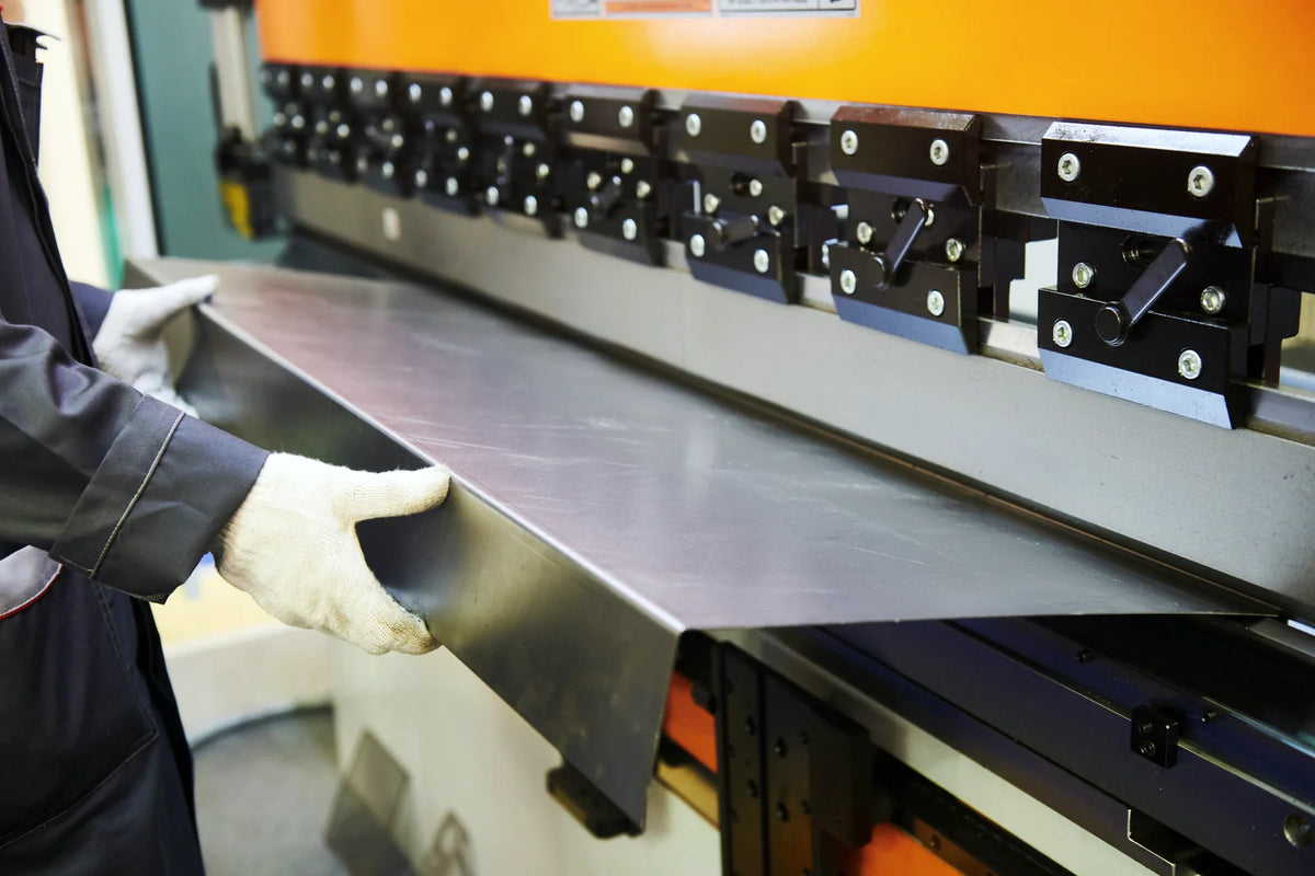 Operator bending a steel sheet on a press brake