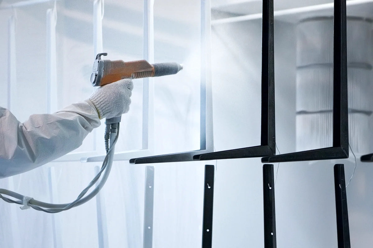 Powder coating metal brackets in a spray booth